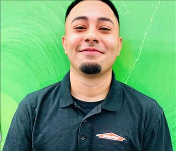 Smiling young man with dark hair and a small chin beard wearing a SERVPRO labeled golf shirt