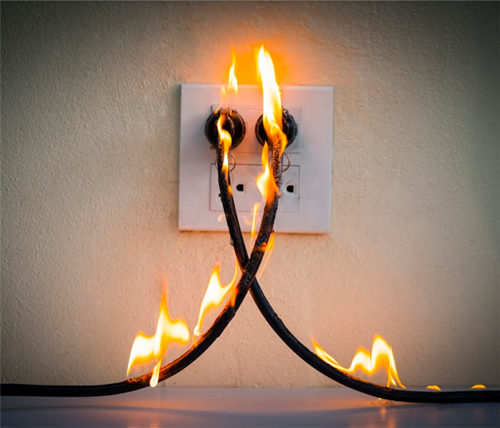 an electrical outlet that has two cords in it that are on fire