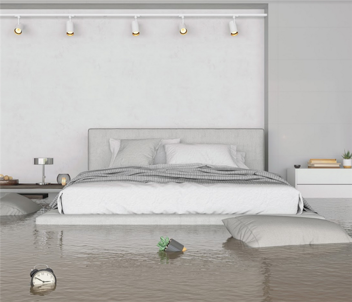 a flooded bedroom with things floating everywhere and water covering the floor